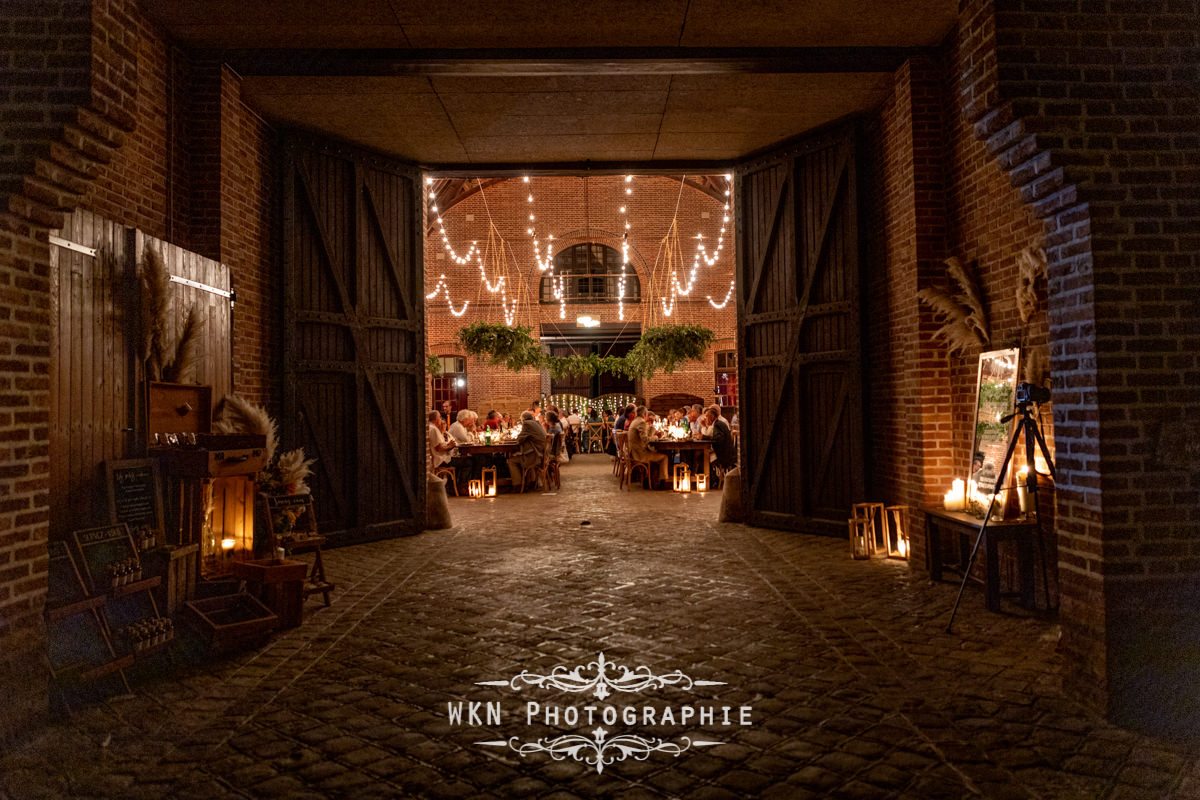 Le photographe jette un dernier regard sur la salle magnifiquement décorée avant de quitter la fête, impressionné par la beauté du lieu et des moments capturés.